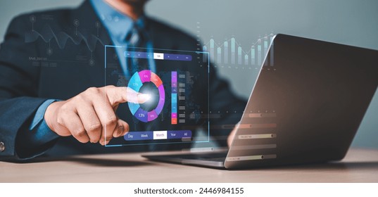 analyst, chart, project, analysis, analytics, diagram, document, graph, management, report. A man is pointing at a laptop screen with a pie chart on it. The pie chart is colorful and has a lot of data