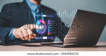 analyst, chart, project, analysis, analytics, diagram, document, graph, management, report. A man is pointing at a laptop screen with a pie chart on it. The pie chart is colorful and has a lot of data