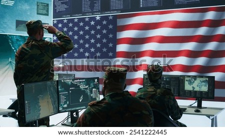 IT analyst in a high tech base of operations handling surveillance activity and ensuring security protocols. Military command post crew collecting real time data to achieve objectives. Camera A.