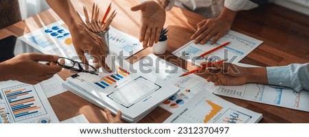 Analyst team utilizing BI Fintech to analyze and pointing at financial dashboard paper office. Businesspeople examining report paper on table for business insight. Panorama shot. Scrutinize