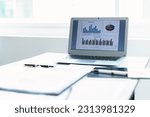 Analytics data with laptop computer at office desk.