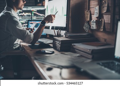 Analyzing data. Close-up of young businessman looking at monitor while sitting at the desk in creative office  - Shutterstock ID 534465127