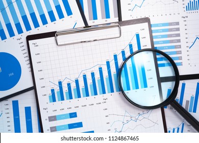 Analyzing and gathering statistical data. Growth charts. Many business reports and magnifying glass.
 - Shutterstock ID 1124867465