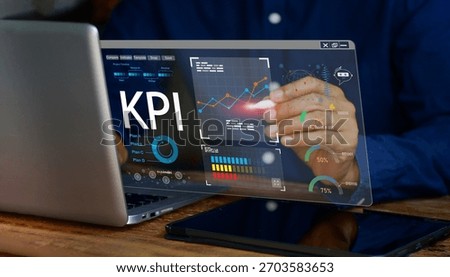 Analyzing Key Performance Indicators. Businessman using digital screen to analyze key performance indicators (KPI) with various graphs and charts,