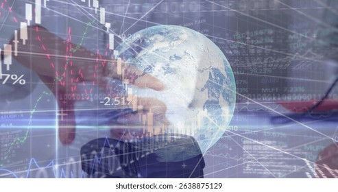 Analyzing suited hand pressing laptop keys at desk with digital globe overlay and financial charts. Technology, finance, data, analysis, strategy, digital, corporate