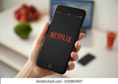 Anapa, Russia - July 21, 2019: Woman holding iPhone 8 Plus with multinational entertainment company Netflix provides streaming media and video on the screen.
