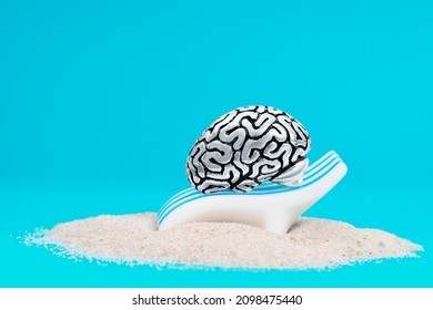 Anatomical Copy Of A Human Brain Lying On A Sunbed On A Sandy Beach. Taking A Break For A Healthy Mindset.