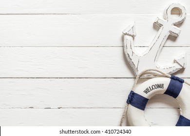 Anchor and lifebuoy on white wood table