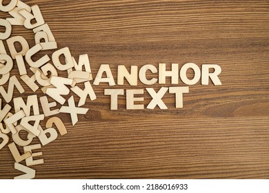 ANCHOR TEXT written with solid letters on a board. Wooden letters on wooden background.