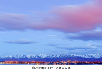 Anchorage Alaska skyline in winter at dusk with the Chugach mountains behind.