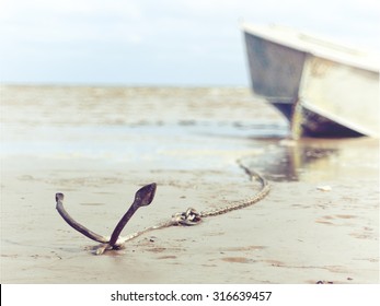 Anchored On The Shore With Boat In The Background