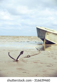 Anchored On The Shore With Boat In The Background