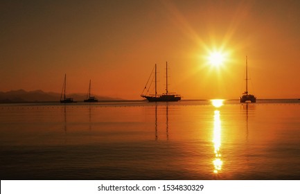 Anchored Sailboats In The Bay At Sunrise. Port Of Datça In Turkey