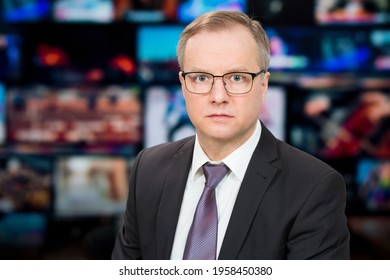 An Anchorman Reporting Live Breaking News Sitting In Tv Studio. Background Of Multiple Screens Of Broadcast Control Room. Journalism Concept