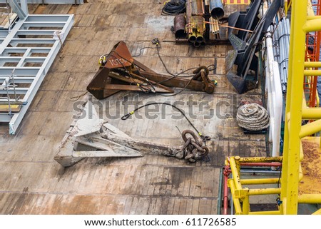 Anchors placed on wooden deck of a construction barge at oilfield