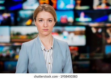 An Anchorwoman Reporting Live Breaking News Sitting In Tv Studio. Background Of Multiple Screens Of Broadcast Control Room. Journalism Concept