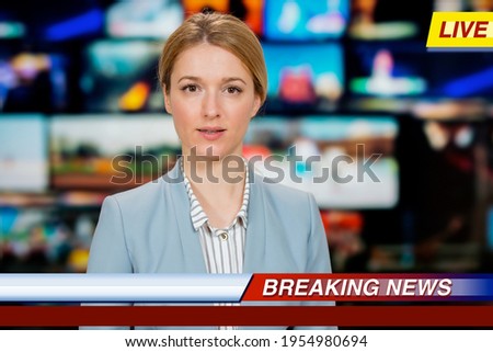 An anchorwoman reporting live breaking news sitting in Tv studio. Background of multiple screens of broadcast control room. Journalism concept