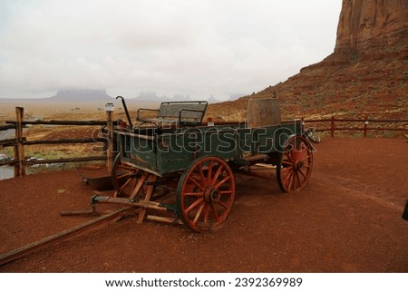 Ancient abandoned horse wagon. Item for a transport wagon. Green wood, red mountain in the background. cloudy sky, Utah, Usa.