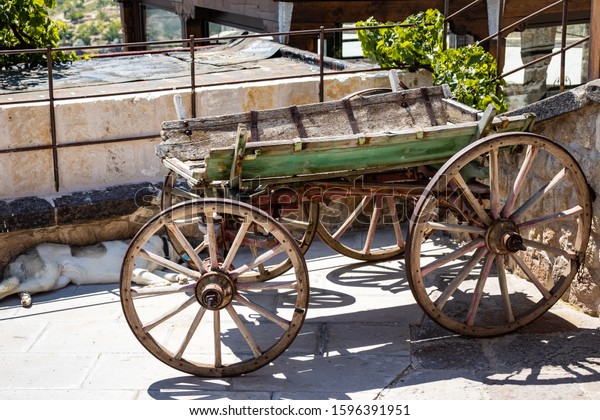 Ancient\
abandoned wooden carriage standing on the\
street.