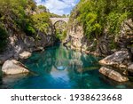 Ancient arch bridge Oluk over the Koprucay river gorge in Koprulu national Park in Turkey. Panoramic scenic view of the canyon and blue stormy mountain river