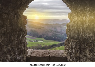 Ancient arch window in the castle at sunset