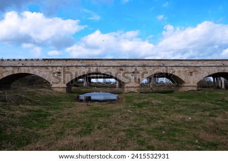 An ancient arched bridge with flowing water, embodying timeless beauty and cultural heritage in a picturesque setting