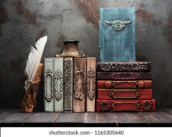 Ancient books, manuscripts and an antique inkwell on a shelf