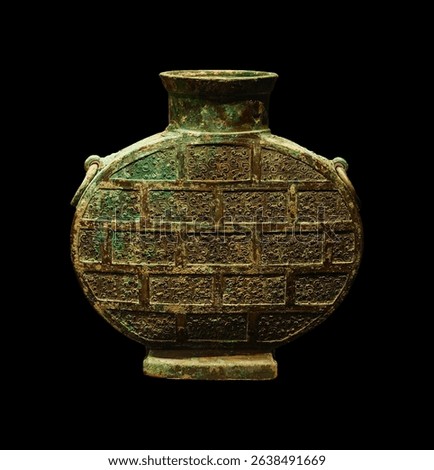 Ancient bronze vessel with a unique brick-patterned design.  Two looped handles adorn its sides.  The patina reveals age and craftsmanship.