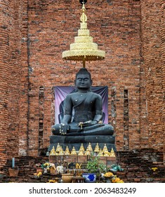 Ancient Buddha Statue And The Wall Made By Old Red Brick Background At Wat Thammikarat In The Historical Park Of Ayutthaya Thailand. Selective Focus.