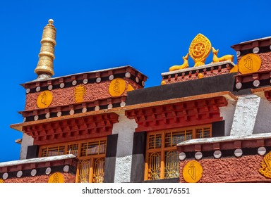 Ancient Buddhist Key monastery with a Wheel of Dharma (Dharmachakra) on the background of blue sky at sunrise