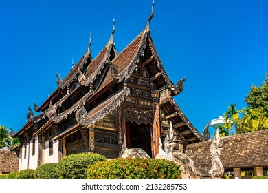 Ancient Buddhist Temple Decorated With Carved Wooden Pattern And Stain Glass With Serpent Sculptures At The Stairway Under Blue Sky