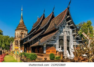 Ancient Buddhist Temple Decorated With Carved Wooden Pattern And Stain Glass With Serpent Sculptures At The Stairway Under Blue Sky