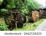 Ancient building wooden turbine baler or antique architecture wood water wheels chinese style in canal for treatment water on pool pond in Huanglong Dong Scenic Area at Zhangjiajie city in Hunan China