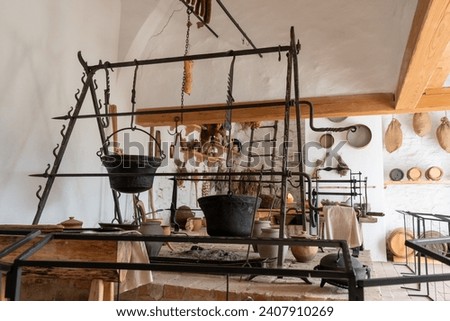 Ancient castle kitchen with hanging cauldrons and herbs.