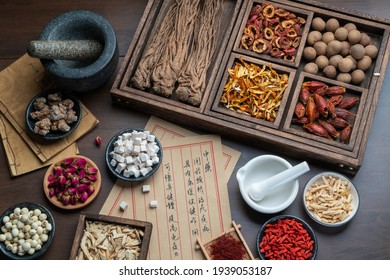 Ancient Chinese medicine books and herbs on the table.English Translation:Traditional Chinese medicine is used in the prevention and treatment of diseases, has the function of rehabilitation. - Shutterstock ID 1939053187