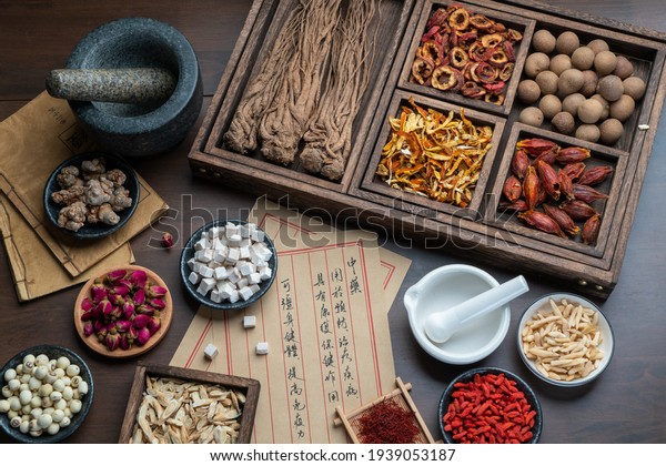 Ancient Chinese medicine books and herbs
on the table.English Translation:Traditional Chinese medicine is
used in the prevention and treatment of diseases, has the function
of rehabilitation.