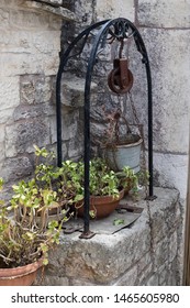 Ancient Cistern With Rusty Pulley And Tin Bucket.