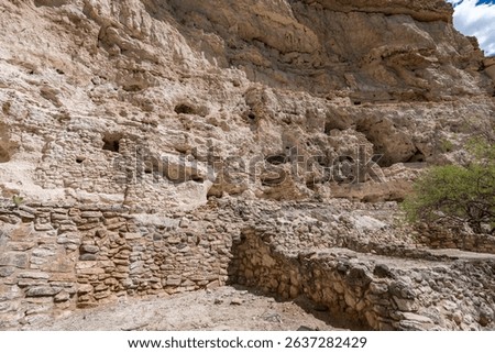 Ancient cliff dwellings built into limestone cliffs in Arizona. Stunning red rock architecture, scenic canyon views, and historic cultural heritage captured in clear desert light