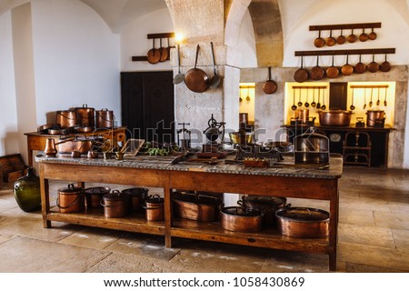 
Ancient copper tableware stands in the kitchen on a larger wooden table in the palace da Pena, Sintra, Lisbon, Portugal