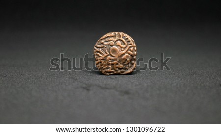An ancient copper Tamil coin of the Chola dynasty.