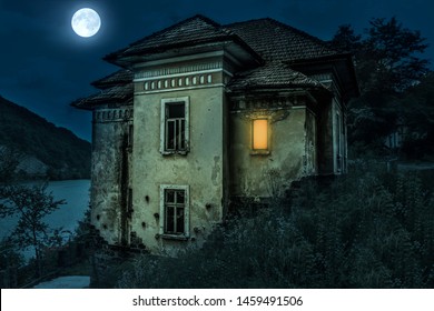 Ancient Creepy House With Spooky Deails In The Moonlight With Dark Horror Atmosphere. Haunted House Scene Like In Halloween Movies. Old Frightful Abandoned Manor With Full Moon In The Ghost Tour