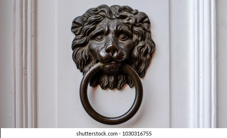 Ancient dark Doorknob in the shape of a Lion at white door