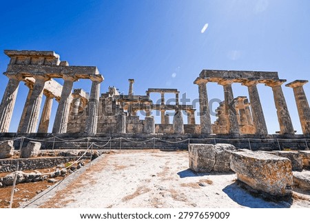 Ancient Doric columns standing under a bright blue sky, revealing historical heritage