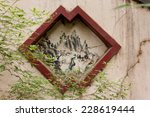 Ancient drawing with red frame inset into a cracked wall near Boya Pagoda at Peking University, Beijing