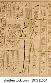 Ancient Egyptian Bas Relief Of A Priestess Offering To The God Of The Nile Hapi, Also Known As Hapy.  Carving On An Outer Wall Of Dendera Temple, Qena, Egypt. Ancient Carving, On Display 1000 Years.