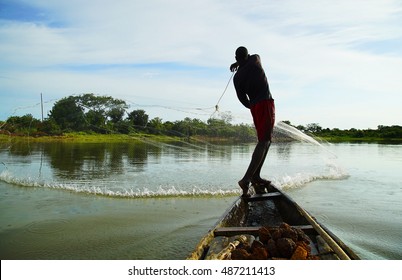 Ancient fishing technique remained unchanged in Africa.
Fisherman throwing a fishing net.
The fisherman is back and is positioned on the edge of a traditional African craft.
