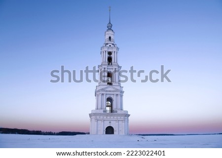 Ancient flooded belfry of St. Nicholas Cathedral on the Uglich reservoir in January dawn. Kalyazin. Tver region, Russia