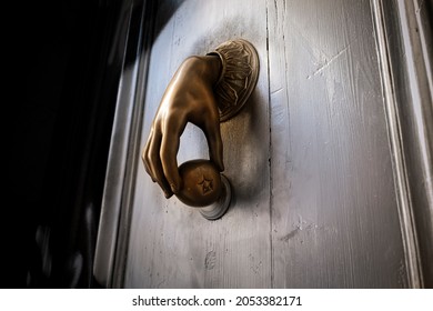 Ancient Golden Knocker With Ball Against Wooden Door