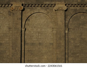 Ancient gothic stone wall with arches and columns. Weathered stone wall with columns