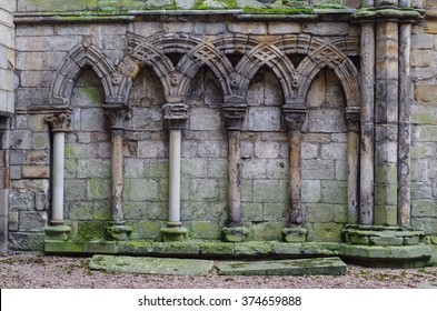 Ancient gothic stone wall with arches and columns, ruins Holyrood Palace in Edinburgh, Scotland, UK